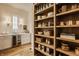 Charming pantry area with custom cabinetry, a beverage center, open wooden shelves and modern lighting fixtures at 3588 Marketplace Ct, Zionsville, IN 46077