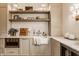 Walk-in pantry features custom cabinetry, a marble countertop, wooden floating shelves, and modern appliances at 3588 Marketplace Ct, Zionsville, IN 46077