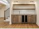Basement wet bar with custom wood cabinetry, beverage fridge, marble countertop and modern fixtures at 3588 Marketplace Ct, Zionsville, IN 46077