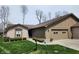 Charming single-story home with a two-car garage and well-manicured lawn and appealing landscaping at 3636 Woodglen Way, Anderson, IN 46011