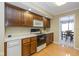 Efficient kitchen with wooden cabinetry, white appliances, and an adjacent dining area at 3636 Woodglen Way, Anderson, IN 46011