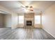 Open living room boasts a brick fireplace, ceiling fan and grey wood-look flooring at 436 N Shore Ct, Franklin, IN 46131