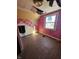 An empty bedroom that needs repairs with a destroyed ceiling, an open wall, and faded pink and yellow walls at 439 N Colorado Ave, Indianapolis, IN 46201
