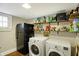 Basement laundry area with washer, dryer, fridge, and storage shelving at 4517 Central Ave, Indianapolis, IN 46205