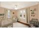 Light-filled Bedroom with crib, chair, and decorative shelves, creating a warm and inviting space at 4517 Central Ave, Indianapolis, IN 46205