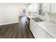 Modern kitchen with white cabinets, stainless steel sink, and wood-look flooring at 4721 N Longworth Ave, Indianapolis, IN 46226