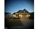 Beautiful home exterior at dusk, featuring a well-lit facade, two-car garage, and a neatly paved driveway at 5003 Lilium Dr, Plainfield, IN 46168