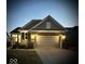 Charming single-Gathering home featuring a brick facade, two-car garage, and manicured lawn at twilight at 5003 Lilium Dr, Plainfield, IN 46168