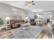 Bright living room featuring hardwood floors, a comfortable sofa, and an open floor plan into the kitchen and dining area at 5003 Lilium Dr, Plainfield, IN 46168