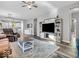 Open-concept living room with media center, ceiling fan, and comfortable furniture at 5003 Lilium Dr, Plainfield, IN 46168