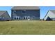 Rear view of the home featuring neutral siding, a large yard, and neatly manicured lawn at 5303 Rum Cherry Way, Indianapolis, IN 46237