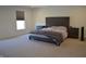 Bright main bedroom with large bed, neutral carpeting, and sunny window at 5303 Rum Cherry Way, Indianapolis, IN 46237