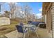 A backyard with a patio, shed, grill, and bare trees in the background at 5832 Emmert Way, Indianapolis, IN 46221