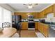 Functional kitchen with wooden cabinetry, modern appliances, and adjacent dining space at 5832 Emmert Way, Indianapolis, IN 46221