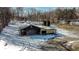 Aerial view of the property with a barn, garage, sheds, and a circular driveway in winter at 6910 S 175 W, Columbus, IN 47201