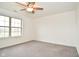 Bright bedroom features a ceiling fan, large window, and neutral carpeting at 7044 Bel Moore Cir, Indianapolis, IN 46259