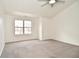 Bedroom features a ceiling fan with light, large window, and neutral carpet at 7044 Bel Moore Cir, Indianapolis, IN 46259