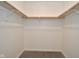 Walk-in closet with custom wooden shelving and neutral colored carpet at 7044 Bel Moore Cir, Indianapolis, IN 46259
