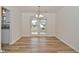 Bright dining area featuring wood-look floors, white walls, and glass patio doors for outdoor access at 7044 Bel Moore Cir, Indianapolis, IN 46259