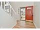 Inviting foyer with wood-look floors, white trim, and a striking red front door with glass inserts at 7044 Bel Moore Cir, Indianapolis, IN 46259