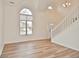 Bright foyer with wood-look floors, a large window, and a white staircase adding architectural interest at 7044 Bel Moore Cir, Indianapolis, IN 46259