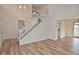 Welcoming foyer showcasing a staircase with white banister and wood-look floors for a modern touch at 7044 Bel Moore Cir, Indianapolis, IN 46259