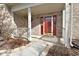 Charming covered front porch with a vibrant red door, brick columns, and manicured landscaping at 7044 Bel Moore Cir, Indianapolis, IN 46259