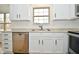 Close-up of kitchen area showcasing granite countertops, stainless steel dishwasher, and white cabinetry at 7044 Bel Moore Cir, Indianapolis, IN 46259