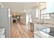 Open-concept kitchen with modern white cabinets, stainless steel appliances, and hardwood flooring at 7044 Bel Moore Cir, Indianapolis, IN 46259