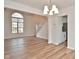 Bright living room featuring hardwood floors, large arched window, and an elegant chandelier at 7044 Bel Moore Cir, Indianapolis, IN 46259