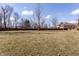 Large backyard with a wooden fence surrounding, set beneath a clear blue sky with scattered clouds at 7411 Perrier Dr, Indianapolis, IN 46278