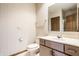 Bathroom featuring a white vanity, toilet, and a mirror with wallpapered walls for added style at 7411 Perrier Dr, Indianapolis, IN 46278