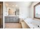 Bright bathroom featuring a soaking tub, double vanity with neutral cabinetry, and a large window at 7411 Perrier Dr, Indianapolis, IN 46278