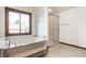 Bright bathroom featuring a soaking tub, tiled shower, and a large window at 7411 Perrier Dr, Indianapolis, IN 46278