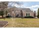Stunning brick home featuring a manicured lawn and mature trees on a sunny day at 7411 Perrier Dr, Indianapolis, IN 46278