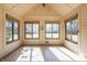 Cozy sunroom filled with natural light, featuring tile flooring and multiple windows overlooking the backyard at 7411 Perrier Dr, Indianapolis, IN 46278