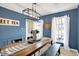 Charming dining room features blue walls, a rustic table, and plenty of natural light at 803 Hickory Way, Noblesville, IN 46062