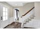 Inviting foyer features hardwood floors, a staircase with white risers, and a white front door at 803 Hickory Way, Noblesville, IN 46062