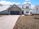 Two-story home with a gray brick garage and driveway, green grass, and a blue sky at 8310 Bearberry Ln, Pendleton, IN 46064