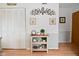 Hallway with wood-look floors, white closet doors, console table and decorative artwork at 8430 Lockwood Ln, Indianapolis, IN 46217