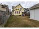 Backyard with view of yellow home, a wood fence and a small lawn at 85 N Dearborn St, Indianapolis, IN 46201