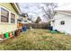 Fenced backyard with yellow home siding, white garage and scattered lawn at 85 N Dearborn St, Indianapolis, IN 46201