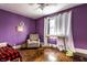This bedroom has purple paint, hardwood floors, and a ceiling fan at 85 N Dearborn St, Indianapolis, IN 46201