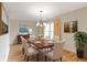 Inviting dining room with a wood table, chandelier, and bright window view at 8751 Jaffa Court E Dr # 17, Indianapolis, IN 46260