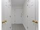 Hallway with white doors and gold hardware and tiled floors at 8751 Jaffa Court E Dr # 17, Indianapolis, IN 46260