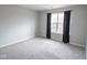 A carpeted bedroom featuring a window with black curtains allowing in natural light at 9078 N River Chase Ln, McCordsville, IN 46055