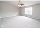 Spacious bedroom featuring neutral carpet, a ceiling fan with lights, and a large window at 9078 N River Chase Ln, McCordsville, IN 46055