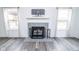 Cozy fireplace with tile surround and decorative screen, flanked by windows with patterned curtains at 9078 N River Chase Ln, McCordsville, IN 46055