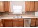 Kitchen view showcasing the stainless steel dishwasher, double sink, tile backsplash, and ample cabinet storage at 9078 N River Chase Ln, McCordsville, IN 46055