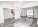 Open-concept living area with updated floors, and stairs in background at 9078 N River Chase Ln, McCordsville, IN 46055